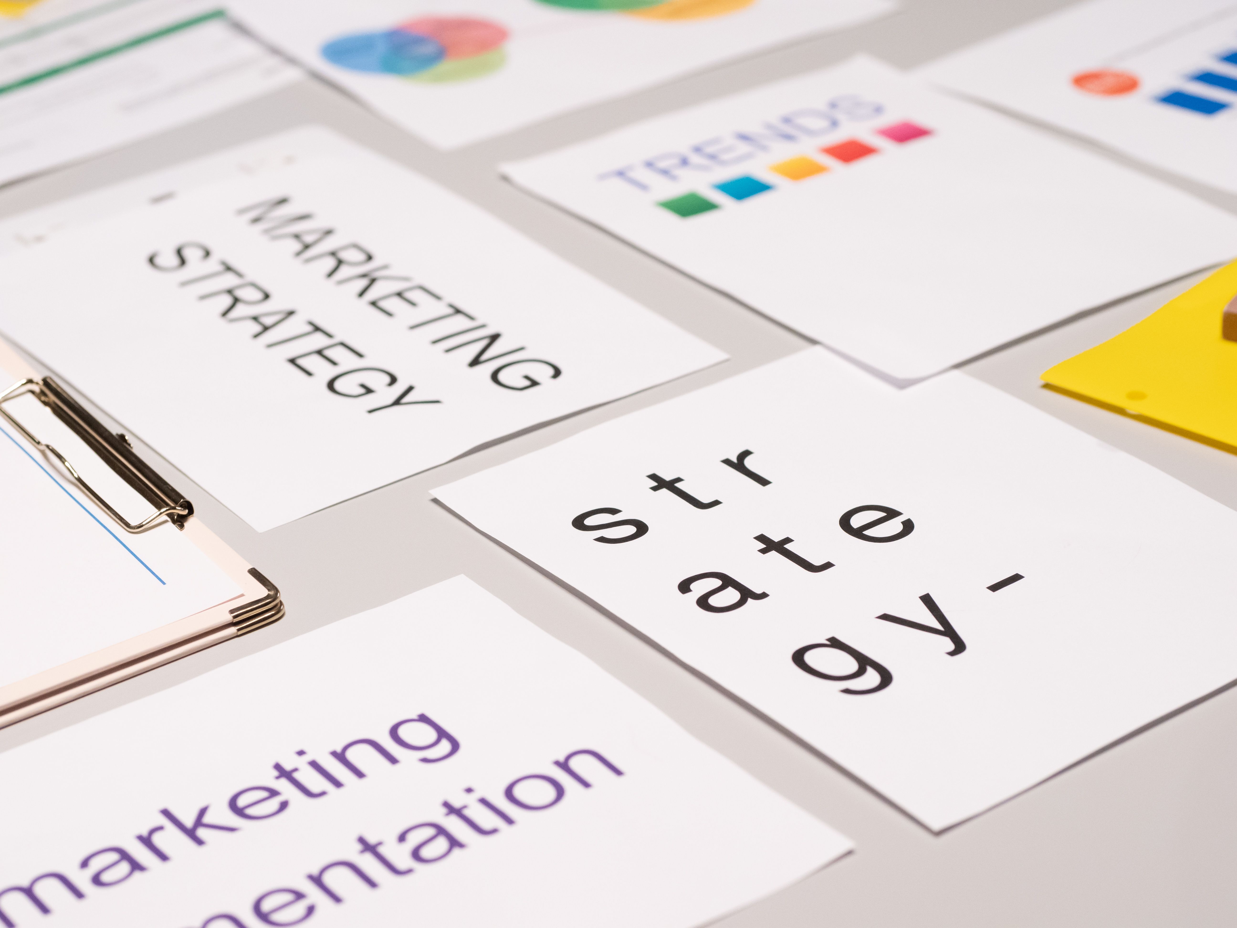 Les prestations de AgorAdora. Vue de dessus de documents et de graphiques de stratégie marketing disposés sur un bureau, illustrant la planification commerciale.